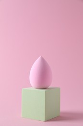 Photo of Stylish presentation of makeup sponge on pink background