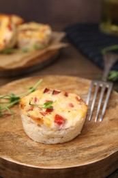 Photo of Delicious egg muffin with cheese and bacon on wooden table, closeup. Space for text