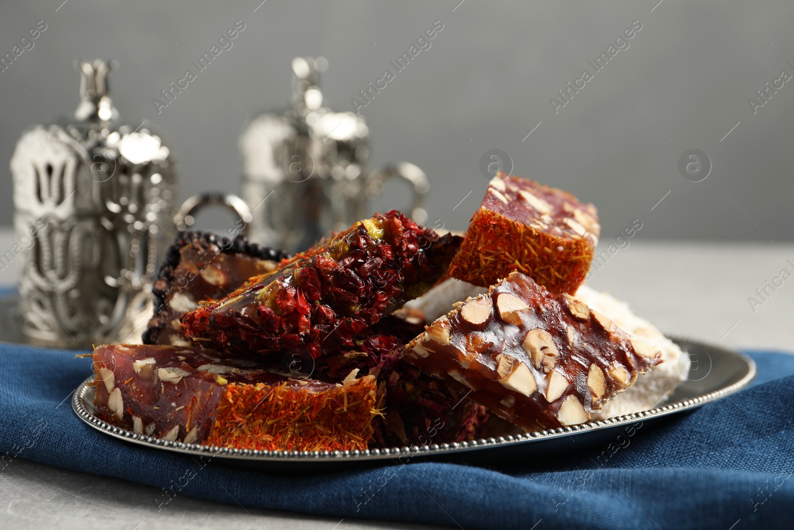 Photo of Tea and Turkish delight served in vintage tea set on grey table, closeup