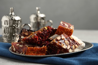 Photo of Tea and Turkish delight served in vintage tea set on grey table, closeup