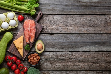 Flat lay composition with keto diet products on wooden table, space for text