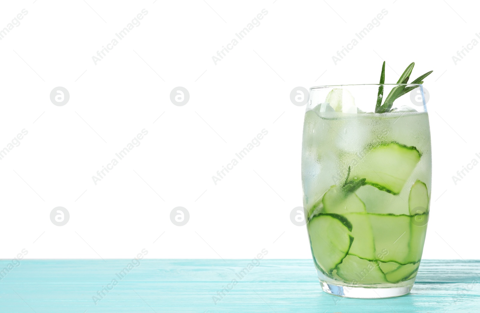 Photo of Glass of refreshing cucumber lemonade and rosemary on blue wooden table against white background. Summer drink