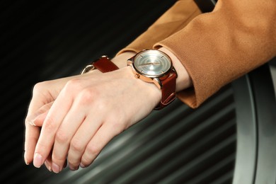 Woman wearing luxury wristwatch near mirror, closeup