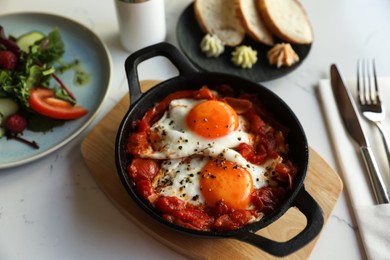 Tasty Shakshouka served on white marble table