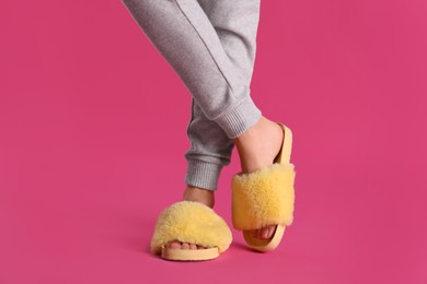 Photo of Woman in fluffy slippers on pink background, closeup