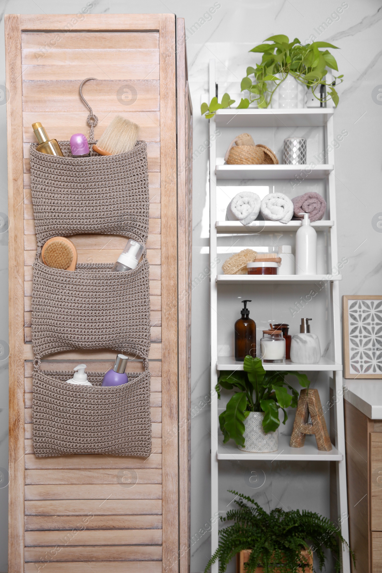 Photo of Knitted organizer hanging on wooden door in bathroom