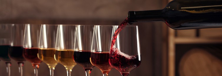 Image of Pouring wine from bottle into glass. Banner design