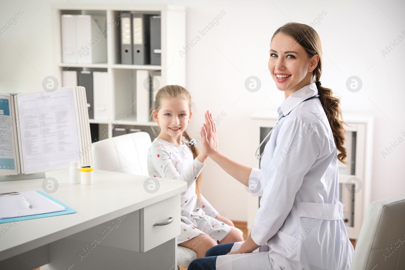 Photo of Children's doctor working with little patient in clinic