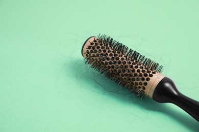 Professional brush with lost hair on green background, closeup. Space for text