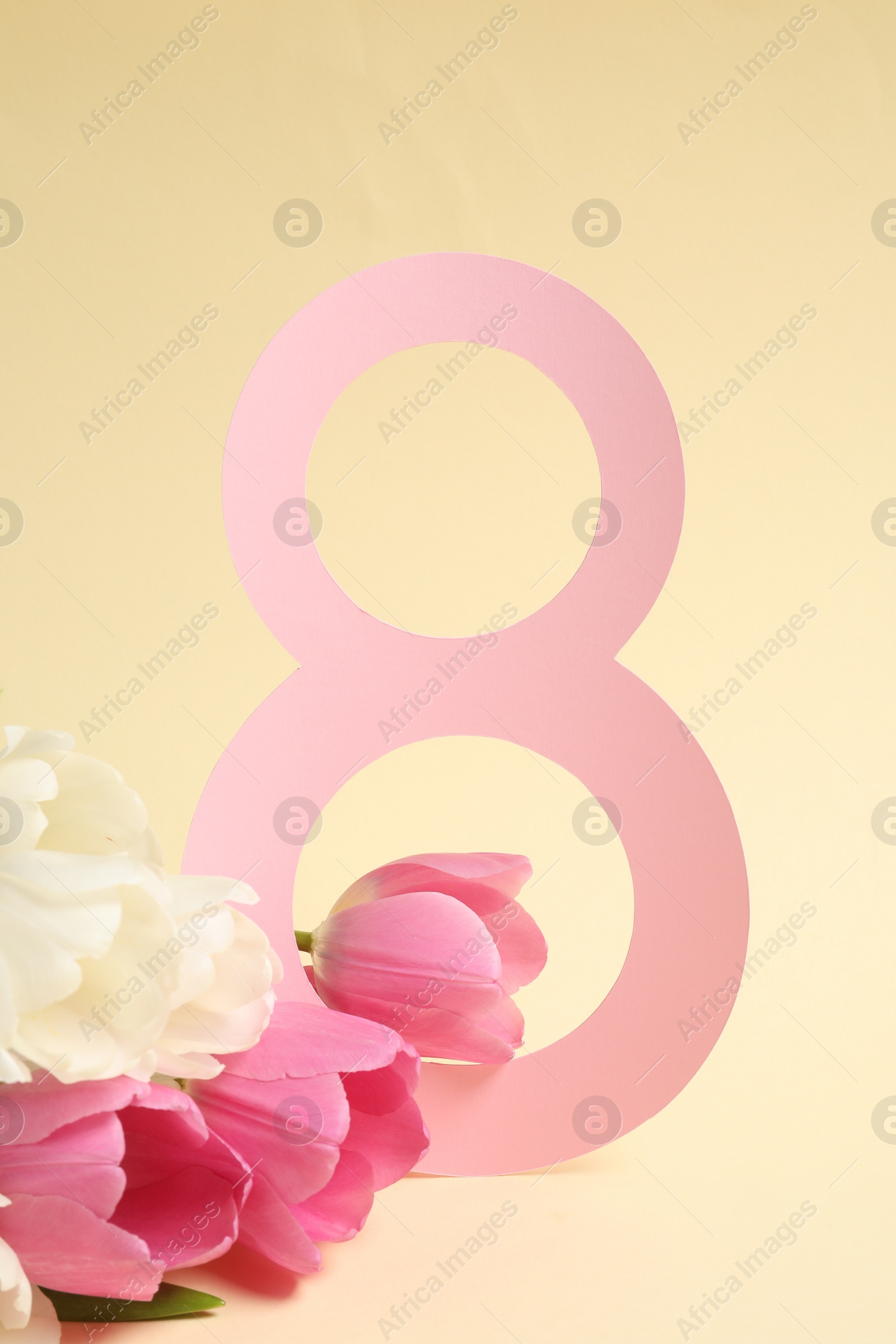 Photo of 8 March greeting card design with beautiful tulips on light yellow background