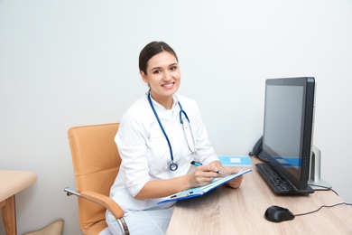 Photo of Portrait of young gynecologist at table in hospital