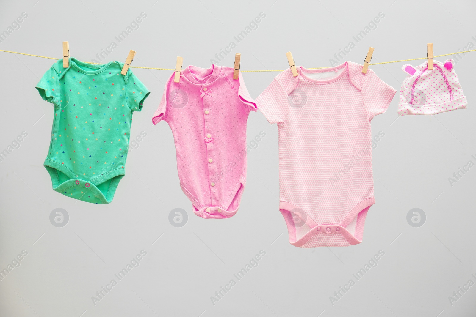 Photo of Children's clothes on laundry line against light background