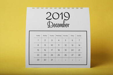 Photo of Paper calendar on yellow background. Planning concept