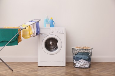 Photo of Laundry room interior with modern washing machine and drying rack