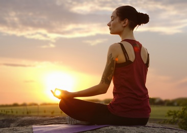 Young woman practicing zen yoga at sunrise outdoors