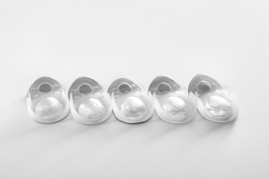 Photo of Packages with contact lenses on white background