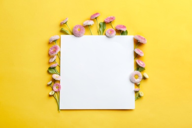 Photo of Flat lay composition with spring daisy flowers and card on color background. Space for text