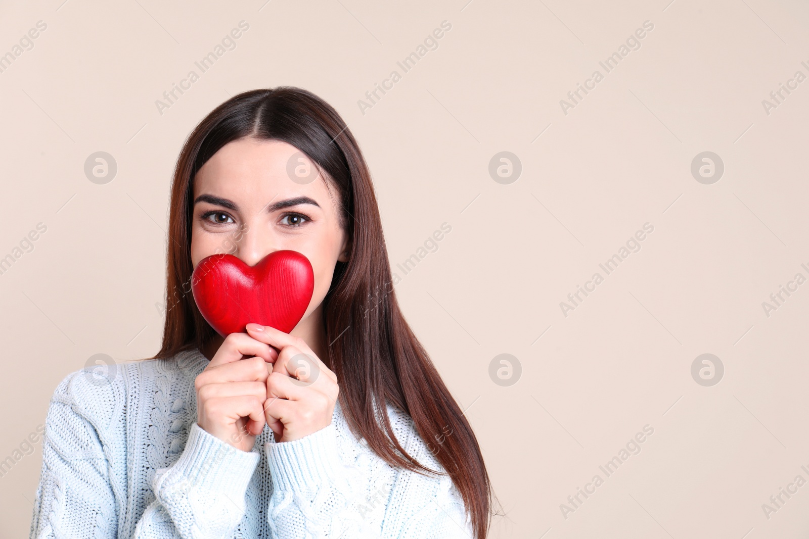 Photo of Portrait of young woman with decorative red heart on color background, space for text