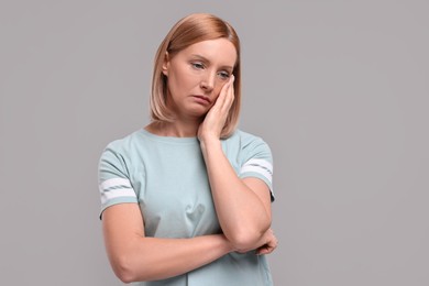 Photo of Portrait of sad woman on grey background