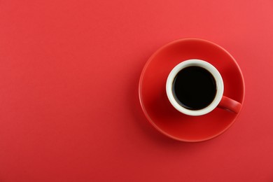 Photo of Cup of tasty coffee on red background, top view. Space for text