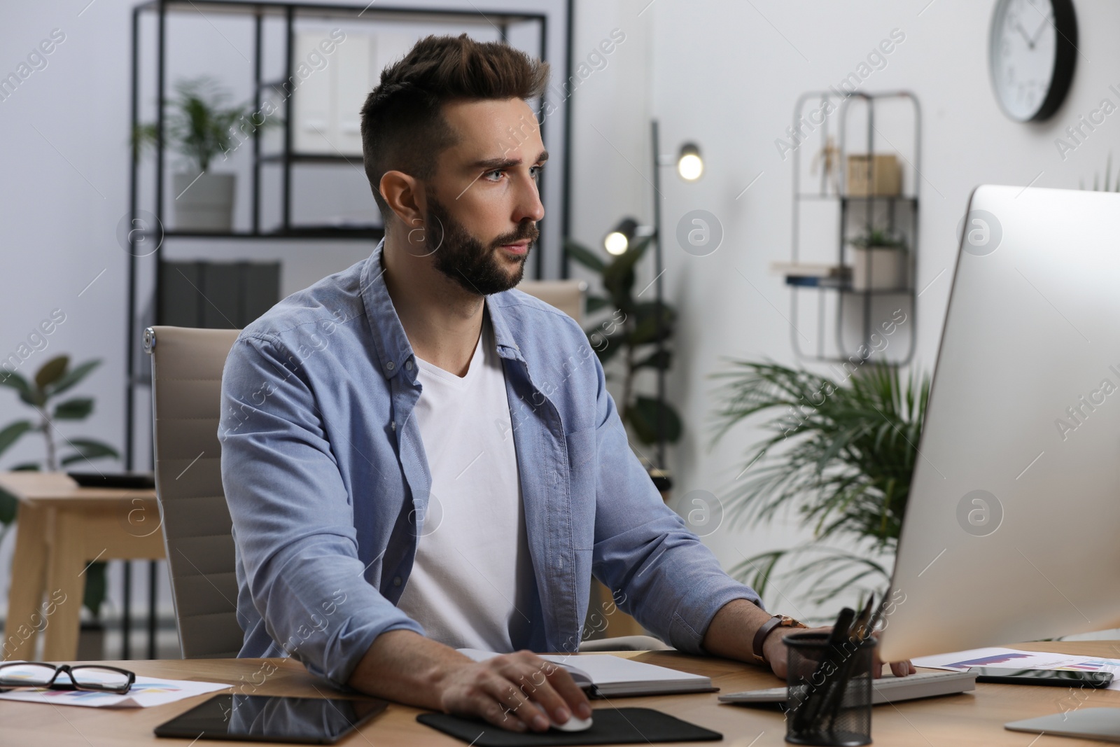 Photo of Man working on computer at table in office