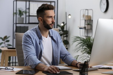 Man working on computer at table in office