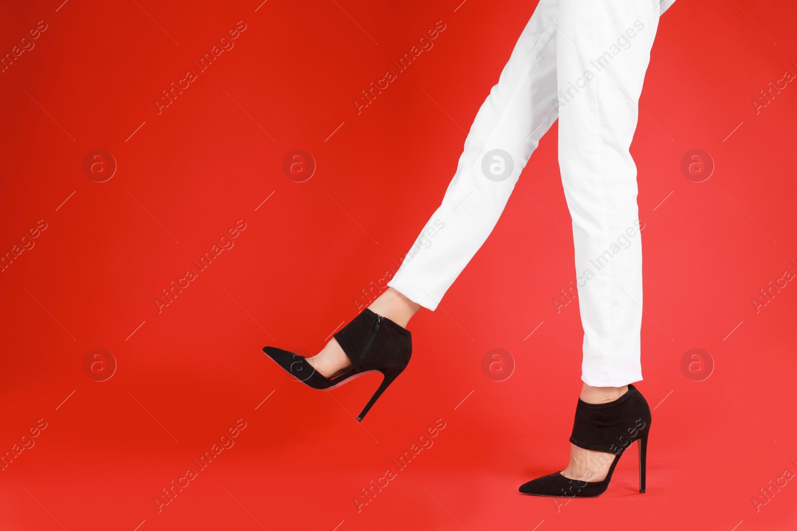 Photo of Woman in elegant shoes on red background