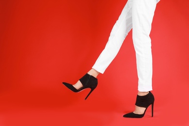 Photo of Woman in elegant shoes on red background