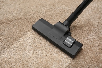 Image of Vacuuming dirty beige carpet. Clean area after using device, closeup