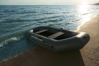 Inflatable rubber fishing boat on sandy beach near sea