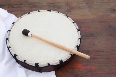 Modern drum with drumstick on wooden table. Space for text