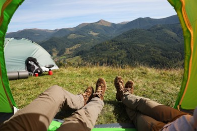 Photo of Couple resting inside of camping tent in mountains, closeup