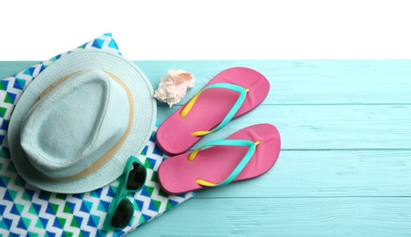 Beach accessories on light blue wooden table, flat lay