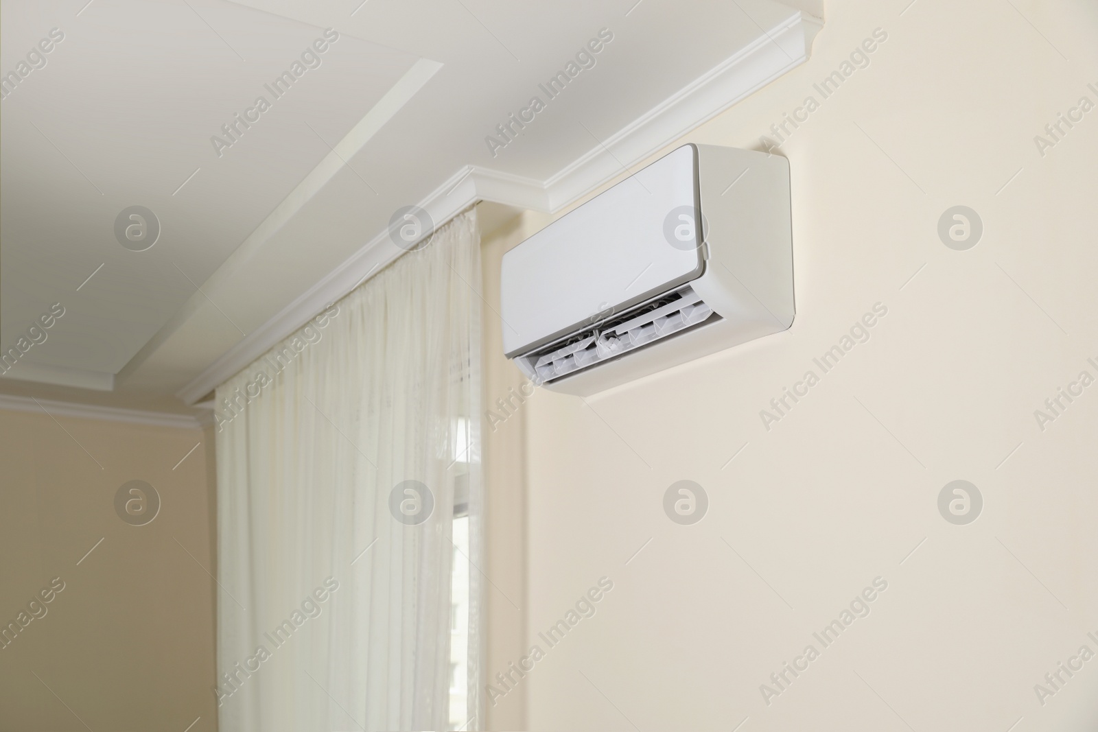 Photo of Modern air conditioner on white wall indoors