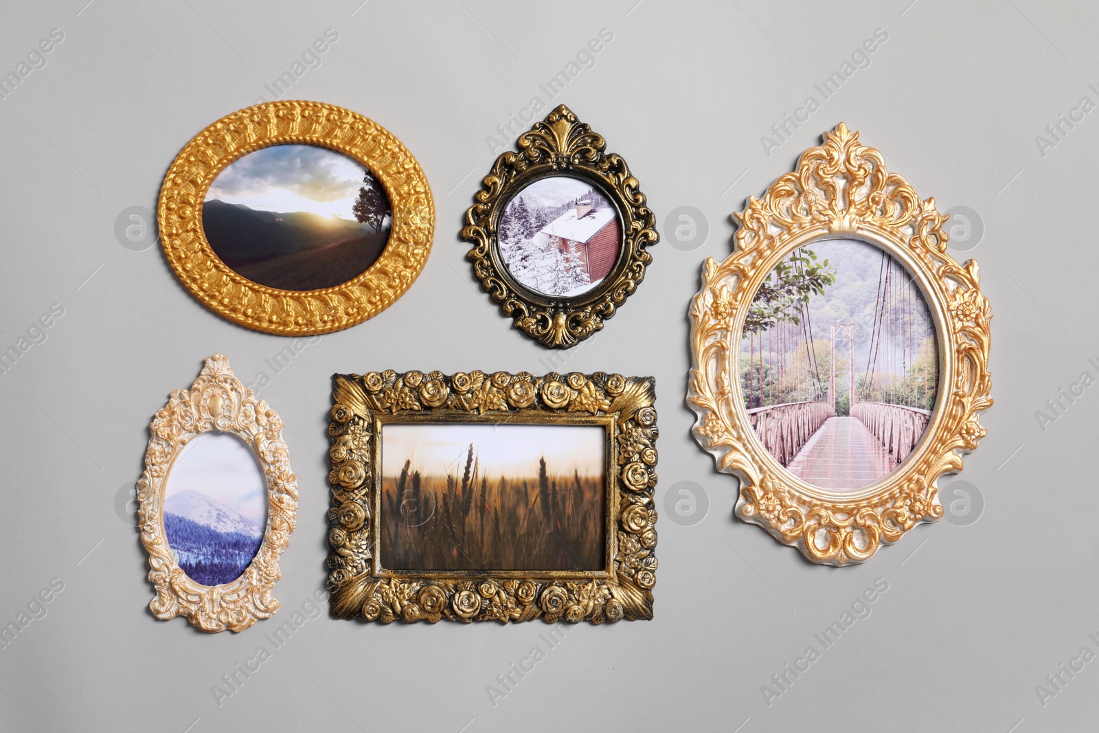 Photo of Vintage frames with beautiful photos of landscapes hanging on light gray wall