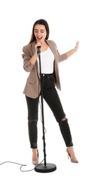 Young stylish woman singing in microphone on white background