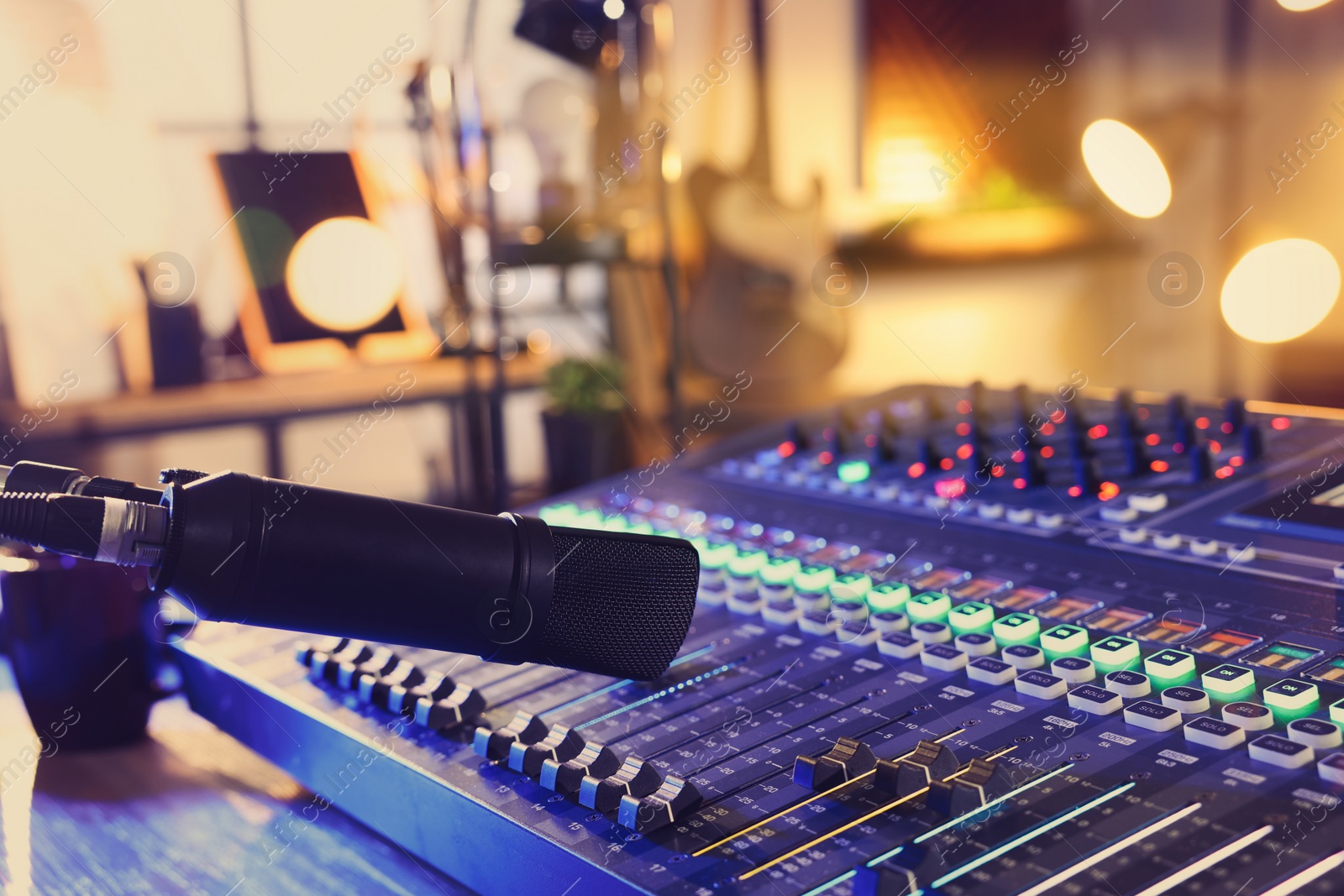 Photo of Microphone over professional mixing console on table in radio studio