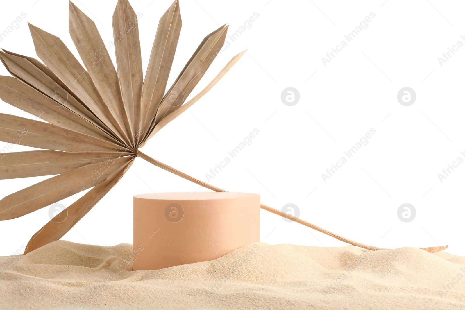 Photo of Presentation of product. Beige podium and palm leaf on sand against white background