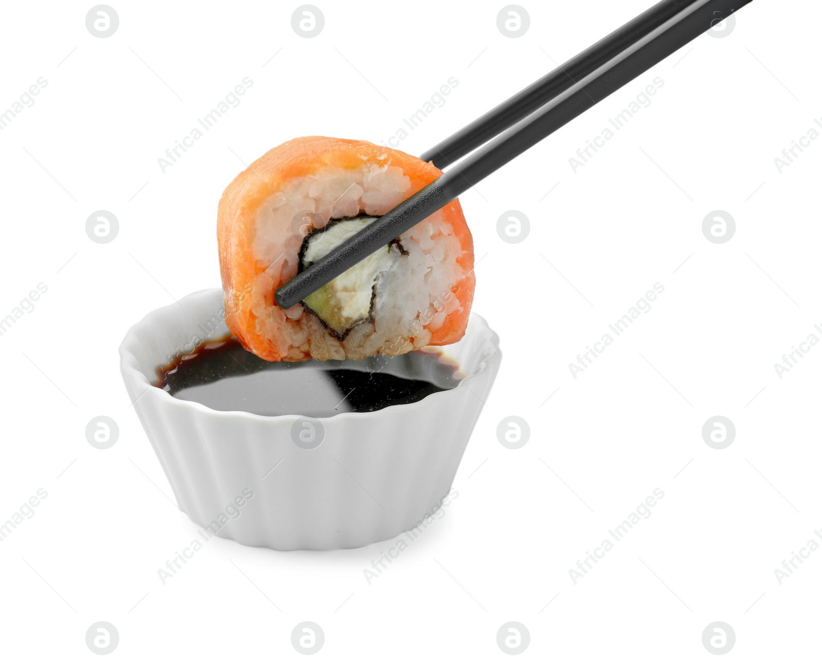 Photo of Dipping tasty sushi into soy sauce isolated on white