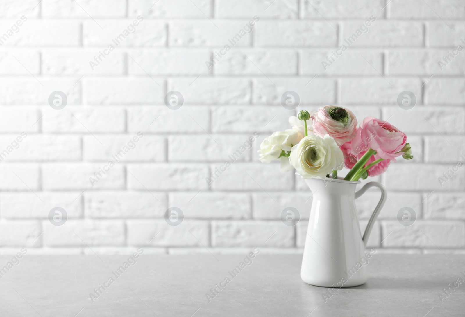 Photo of Vase with beautiful ranunculus flowers on table