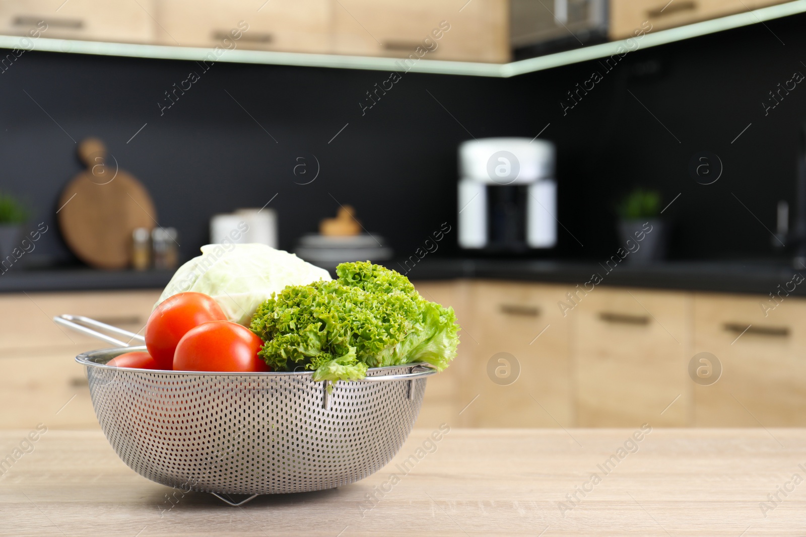 Photo of Fresh vegetables on wooden table in kitchen. Space for text