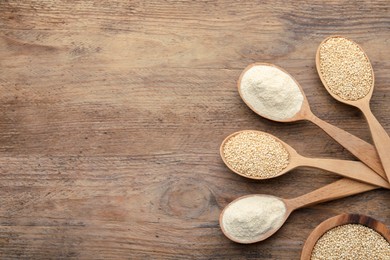 Photo of Spoons with quinoa flour and seeds on wooden table, flat lay. Space for text