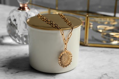 Photo of Stylish presentation of elegant necklace on white marble table, closeup