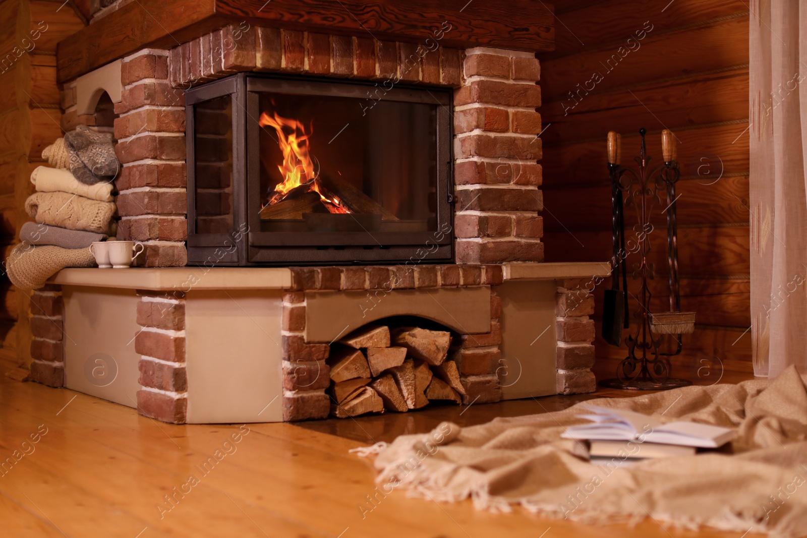 Photo of Fireplace with burning wood in room. Winter vacation