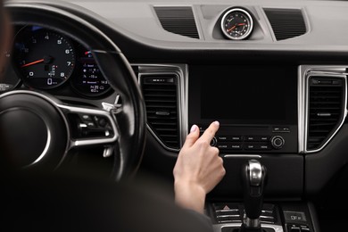 Photo of Woman using navigation system while driving her car, closeup