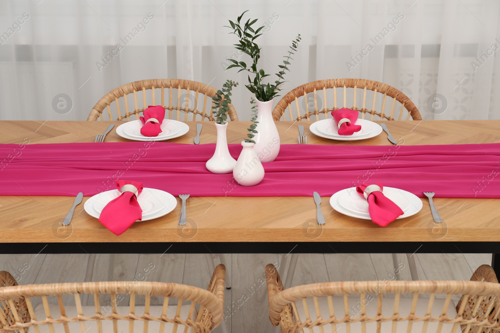 Photo of Beautiful table setting and vases with green branches in dining room