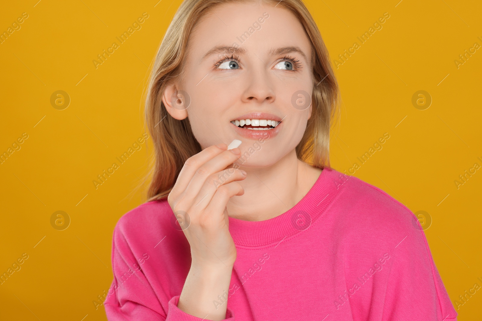 Photo of Happy young woman with bubble gum on yellow background