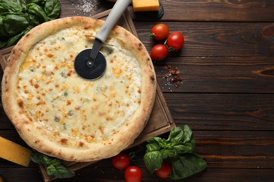 Photo of Delicious cheese pizza and ingredients on wooden table, flat lay. Space for text