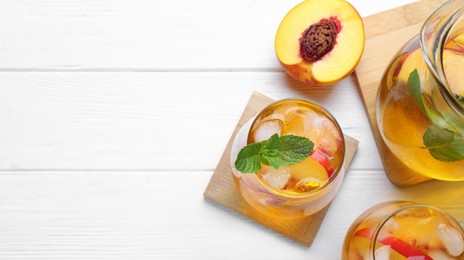 Image of Tasty refreshing soda drink with peach and mint on white wooden table, above view. Banner design with space for text
