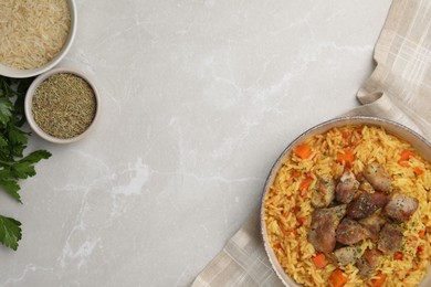Photo of Delicious pilaf with meat and ingredients on light grey marble table, flat lay. Space for text
